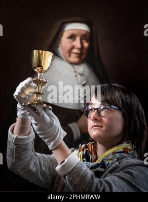 Special collections manager Dr Hannah Thomas holds the 1630s recusant chalice with depictions of the Stations of the Cross on display at the Bar Convent in York, the oldest living convent in the UK, as part of an exhibition for Easter. Picture date: Wednesday March 29, 2023. Stock Photo