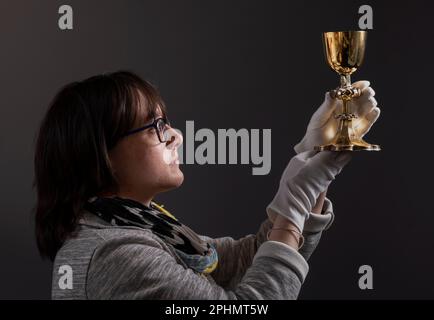 Special collections manager Dr Hannah Thomas holds the 1630s recusant chalice with depictions of the Stations of the Cross on display at the Bar Convent in York, the oldest living convent in the UK, as part of an exhibition for Easter. Picture date: Wednesday March 29, 2023. Stock Photo