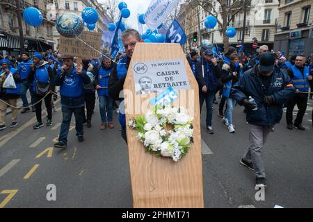 Paris, France. 28th Mar, 2023. A member of the CFTC (French Confederation of Christian Workers) carries a fake coffin that reads 'Caisse de retraite' during a demonstration against pension reform in Paris. President Emmanuel Macron wants to introduce a bill which will raise the retirement age from 62 to 64. (Photo by Lucy North/SOPA Images/Sipa USA) Credit: Sipa USA/Alamy Live News Stock Photo