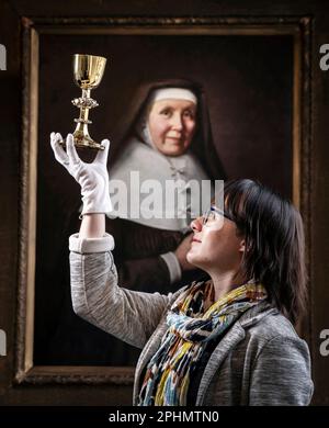 Special collections manager Dr Hannah Thomas holds the 1630s recusant chalice with depictions of the Stations of the Cross on display at the Bar Convent in York, the oldest living convent in the UK, as part of an exhibition for Easter. Picture date: Wednesday March 29, 2023. Stock Photo