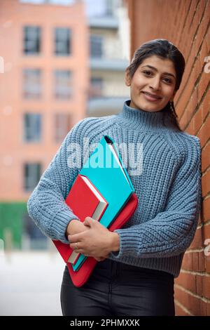 Portrait Of Smiling Female College Or University Student Outside Campus Building With Books Stock Photo