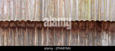 Two-tone weathered wooden facade made of vertical boards with decorative arches Stock Photo