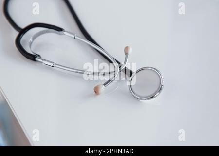 Close up view of medical stethoscope that lying down on white table Stock Photo