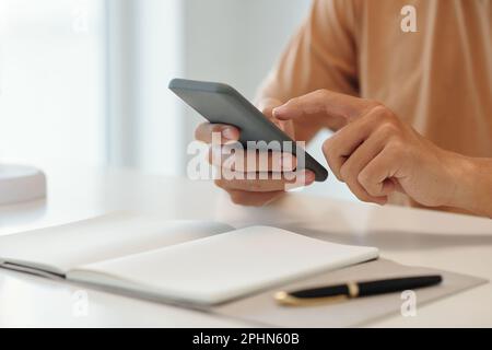 Hands of young businessman using application on smartphone Stock Photo