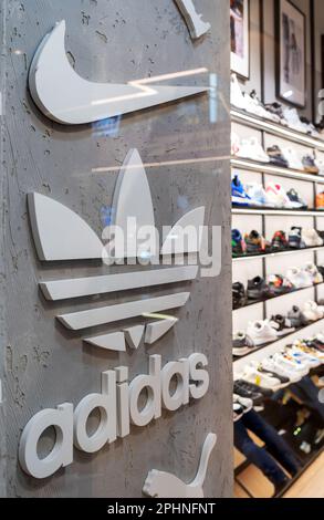 Nike and Adidas Logos of popular footwear and clothing brands in the interior of a multi-brand sport store. Minsk, Belarus, 2023 Stock Photo