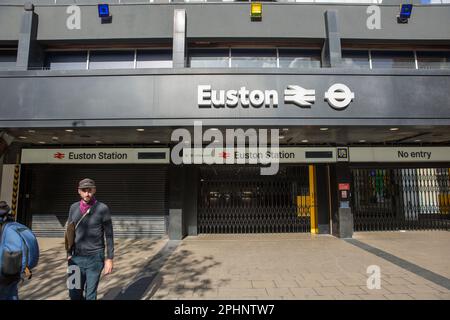 Pedestrians walk past a closed entrance of Euston Station during a rail strike in London. Stock Photo
