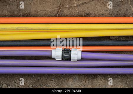 underground electric cable infrastructure installation. Construction site with A lot of communication Cables protected in tubes. electric and high-spe Stock Photo