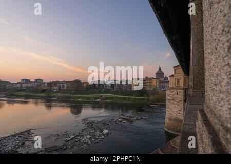 Skyline of Pavia , Ponte Coperto(covered bridge) is a bridge over the Ticino river in Pavia at sunset, Pavia Cathedral background, Italy Stock Photo