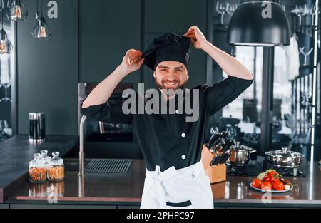 Portrait of professional young chef cook in uniform that posing for camera on the kitchen Stock Photo