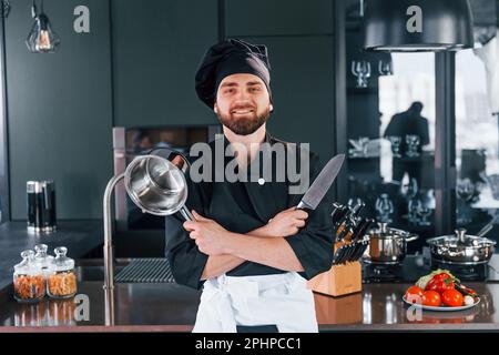 Portrait of professional young chef cook in uniform that posing for camera on the kitchen Stock Photo