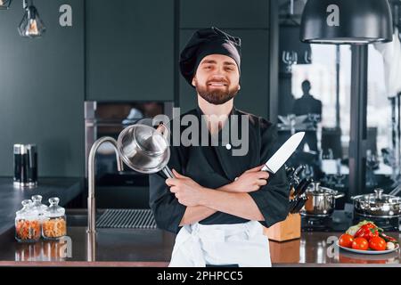 Portrait of professional young chef cook in uniform that posing for camera on the kitchen Stock Photo