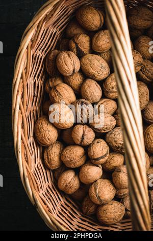 Harvest of walnuts in a basket, top view. Stock Photo