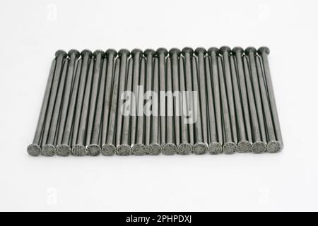 Metal nails neatly stacked on a white background Stock Photo