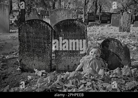 An old cemetery in an 1776 English Reform Church yard. With a one eyed doll. This infrared,abstract,photo is a scary, look for Halloween. Stock Photo