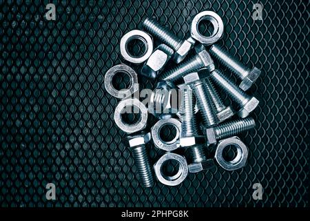 Bolts and nuts on steel surface. Mechanic items for maintenance. Hardware parts to build and repair. Technical tools background Stock Photo