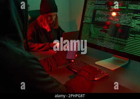 Anonymous people using computer and programming to break code. Cyber security threat. Internet and network security. Access to private information. An Stock Photo