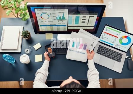 Man entrepreneur having business conversation, video chat on mobile phone. Businessman working with data, charts and graphs on computer screen. Man ho Stock Photo