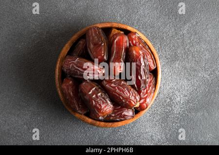 Date fruits in wooden bowl,on black  background Stock Photo