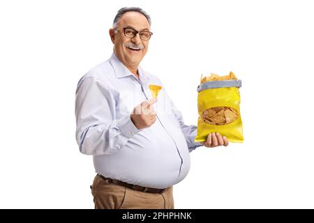 Cheerful mature man eating tortilla crisps and smiling isolated on white background Stock Photo