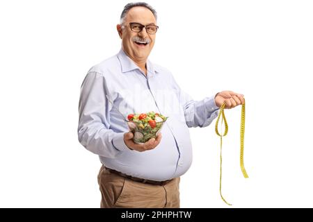 Mature man holding a salad and a measuring tape isolated on white background Stock Photo