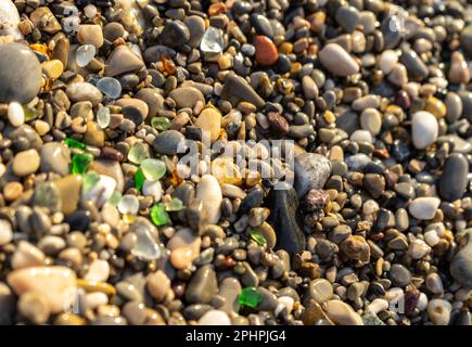 Colored Sea Glasses on Pebble Beach Texture Background, Multicolored Rocky Shore with Copy Space, Macro Glass Stones on Pebble Beach, Selective Focus Stock Photo