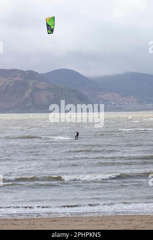 A single Kitesurfer with board, harness and foil enjoying the thrills of surfing in challenging seas off the West shore of Llandudno, North Wales Stock Photo