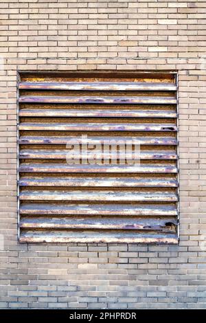 Old Louvre shutters to window of commercial building Stock Photo