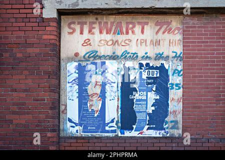 Fly-Posters on warehouse brick wall Stock Photo