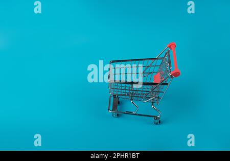 Shopping Basket on Blue Background, Shopping Cart, Shop Cart Mockup, Empty Trolley, Supermarket Cart with Copy Space Stock Photo