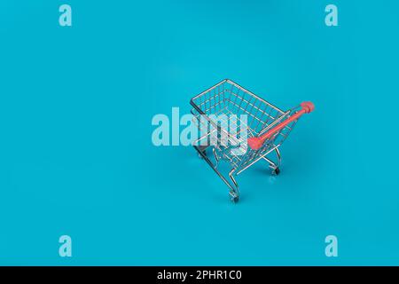 Shopping Basket on Blue Background, Shopping Cart, Shop Cart Mockup, Empty Trolley, Supermarket Cart with Copy Space Stock Photo