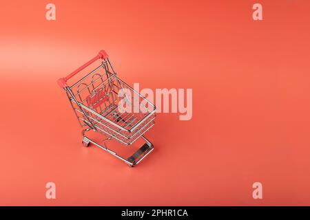 Shopping Basket on Red Background, Shopping Cart, Shop Cart Mockup, Empty Trolley, Supermarket Cart with Copy Space Stock Photo