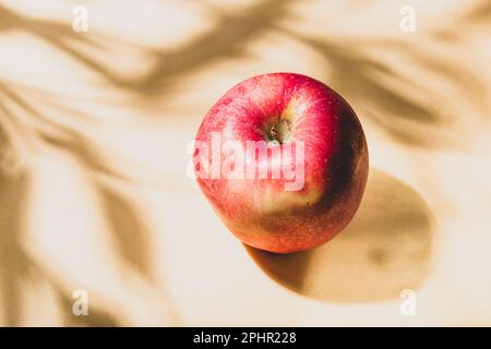 one red apple on a yellow background, view from above Stock Photo