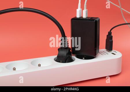 USB Plugs, Power Strip, Extension Cable, Electricity Strip USB Charging, Home Socket, Power Extender, Extension Cord on Pink Background with Copy Spac Stock Photo