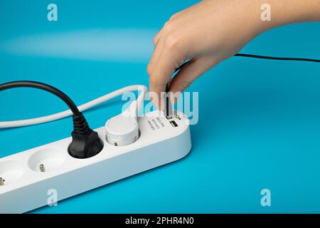 Turning on USB Plugs, Power Strip, Extension Cable, Electricity Strip USB Charging, Home Socket, Power Extender, Extension Cord on Blue Background Stock Photo