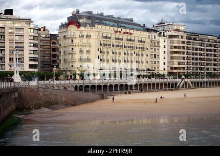 The town's waterfront, the part of beach of La Concha Bay, historic building of the Hotel de Londres, Donostia-San Sebastian, Basque Country, Spain Stock Photo
