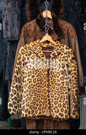 Real fur female coat with leopard print sold on outdoors market Stock Photo
