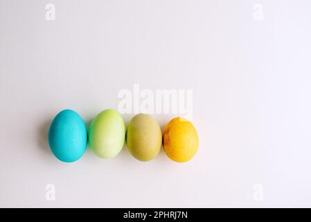 Easter bright, blue, green, orange eggs lie in a row on an isolated white background. Greeting card with place for text. Copy space, mock up Stock Photo