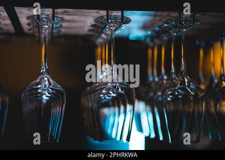set of shiny dry wineglasses over bar counter in nightclub Stock Photo