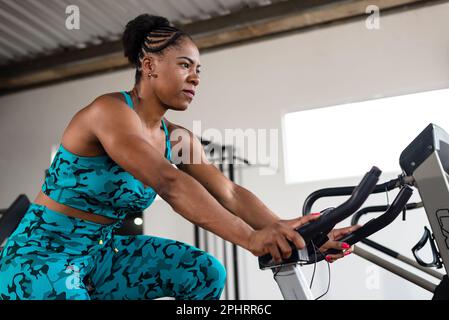 Pretty girl doing exercise on an exercise bike. crossfit gym