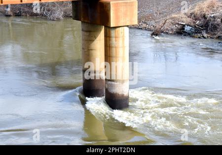 High water from the Neosho River (aka Grand River) hits the concrete piles of the Grand Bridge at Fort Gibson, Oklahoma. Stock Photo
