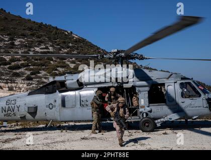 230221-N-YD731-1198 ALBANIA (Feb. 21, 2023) Naval Air Crewman (Helicopter) 2nd Class Jake Rambow, left, assigned to Helicopter Sea Combat Squadron (HSC) 5, unloads Spanish Marines from an MH-60S Nighthawk helicopter during interoperability training, Feb. 21, 2023. Carrier Air Wing (CVW) 7 is the offensive air and strike component of Carrier Strike Group (CSG) 10 and the George H.W. Bush CSG. The squadrons of CVW-7 are Strike Fighter Squadron (VFA) 143, VFA-103, VFA-86, VFA-136, Carrier Airborne Early Warning Squadron (VAW) 121, Electronic Attack Squadron (VAQ) 140, Helicopter Sea Combat Squadr Stock Photo