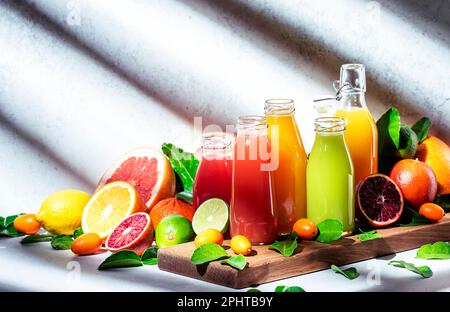 Summer beverages. Citrus fruit juices, fresh and smoothies, food background. Mix of different whole and cut fruits: orange, grapefruit, lime, tangerin Stock Photo