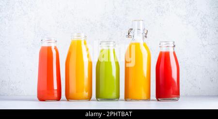 Summer beverages. Citrus fruit juices, fresh and smoothies, food background. Mix of different orange, grapefruit, lime, tangerine drinks in bottles Stock Photo