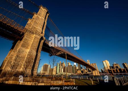 Brooklyn, NY - USA - March 26, 2023 Wide angle horizontal sunrise view of the Brooklyn Bridge from the Emily Warren Roebling Plaza, with an iconic vie Stock Photo