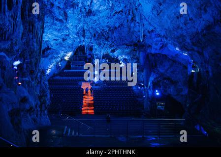 Gilbraltar, Spain UK - May 22 2019: Blue light on stalactites and stalagmites Nerja cave with concert seats in the cave. Stock Photo