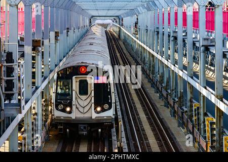 Subway train traveling on tracks across the Williamsburg Bridge from Brooklyn to Manhattan in New York City Stock Photo