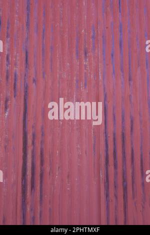 Rusted, red corrugated metal panel with dark streaks. Textured wall background. Weathered, worn out vintage style. Abstract concept. Stock Photo