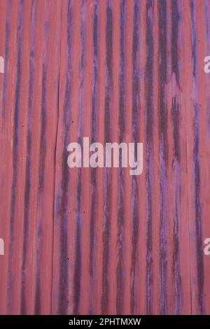 Rusty, red corrugated metal panel with black streaks. Textured wall background. Weathered, rusted vintage style. Stock Photo