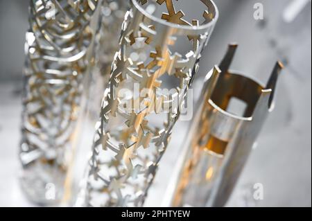 Metal pipes processed with laser cutting machine in shop Stock Photo