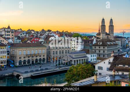 Sunrise view of quay of river limmat in Zuerich dominated by the town hall and Grossmuenster cathedral, Switzerland. Stock Photo